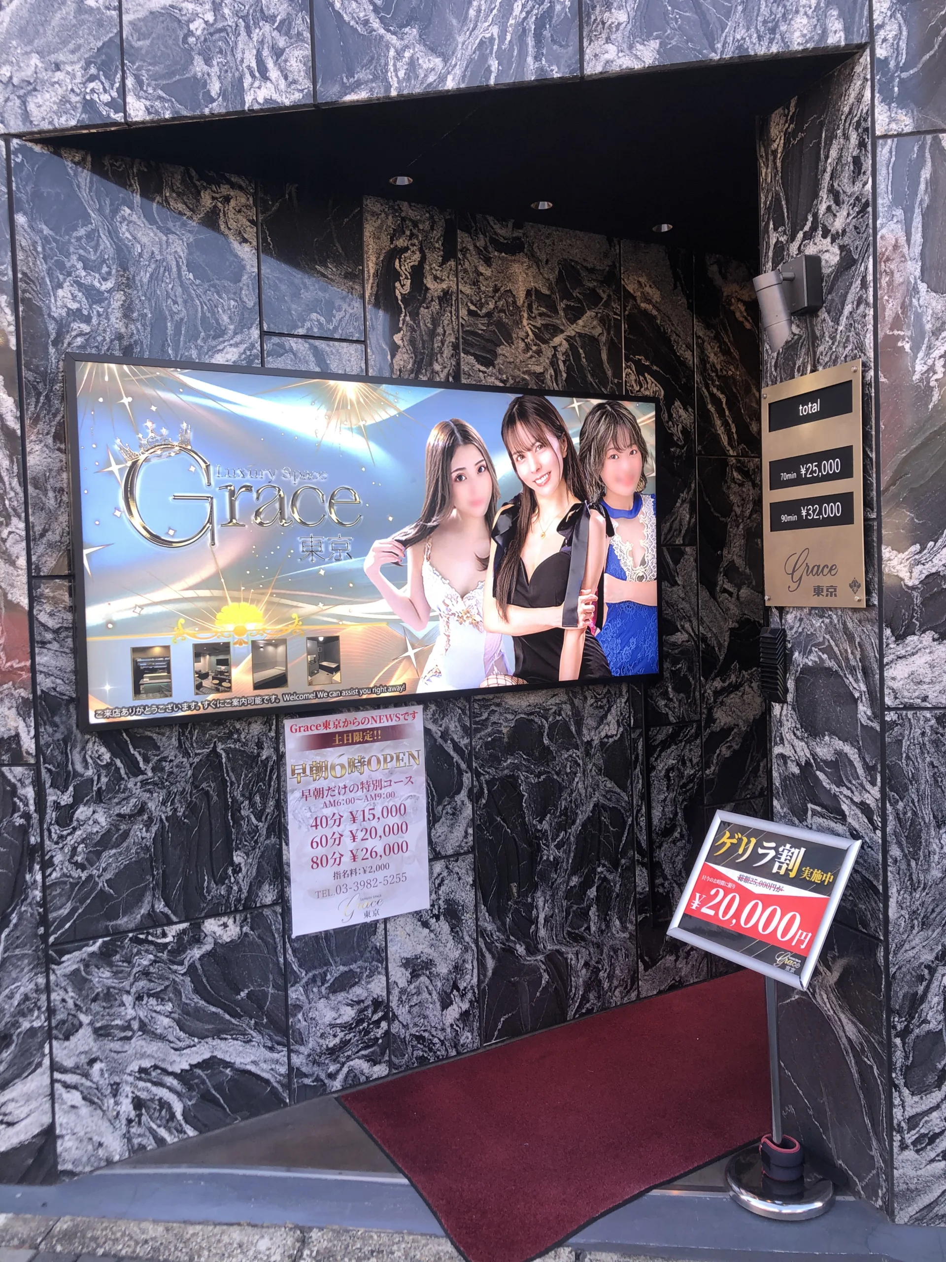 Entrance to a luxury venue in Tokyo with signage and pricing, highlighting nightlife options for Japan tour visitors.