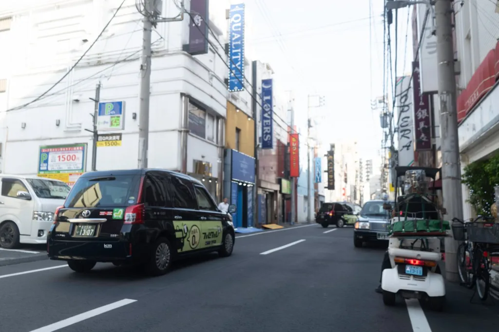 Busy Tokyo street scene with taxis and shops, highlighting urban exploration on Japan tours.