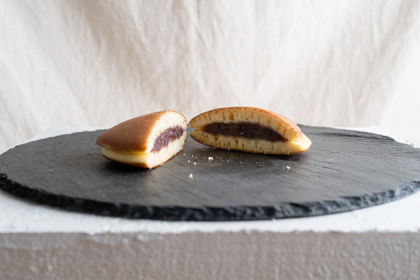 Sección transversal de dos dorayaki: una versión de tienda de conveniencia (izquierda) frente a una versión de tienda especializada (derecha) que muestra la diferencia en el relleno de anko