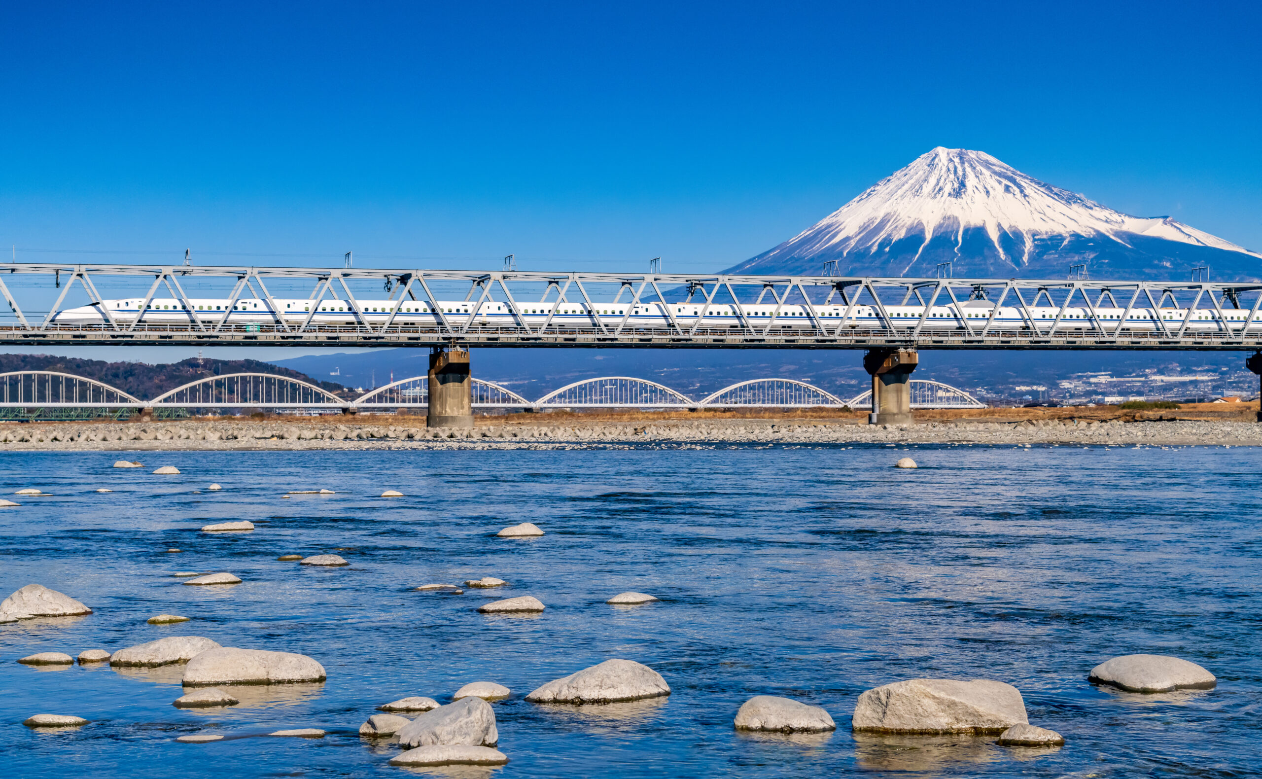 Discover Japan by bullet train with stunning views of Mount Fuji and serene rivers. Perfect for Japan tour adventures.