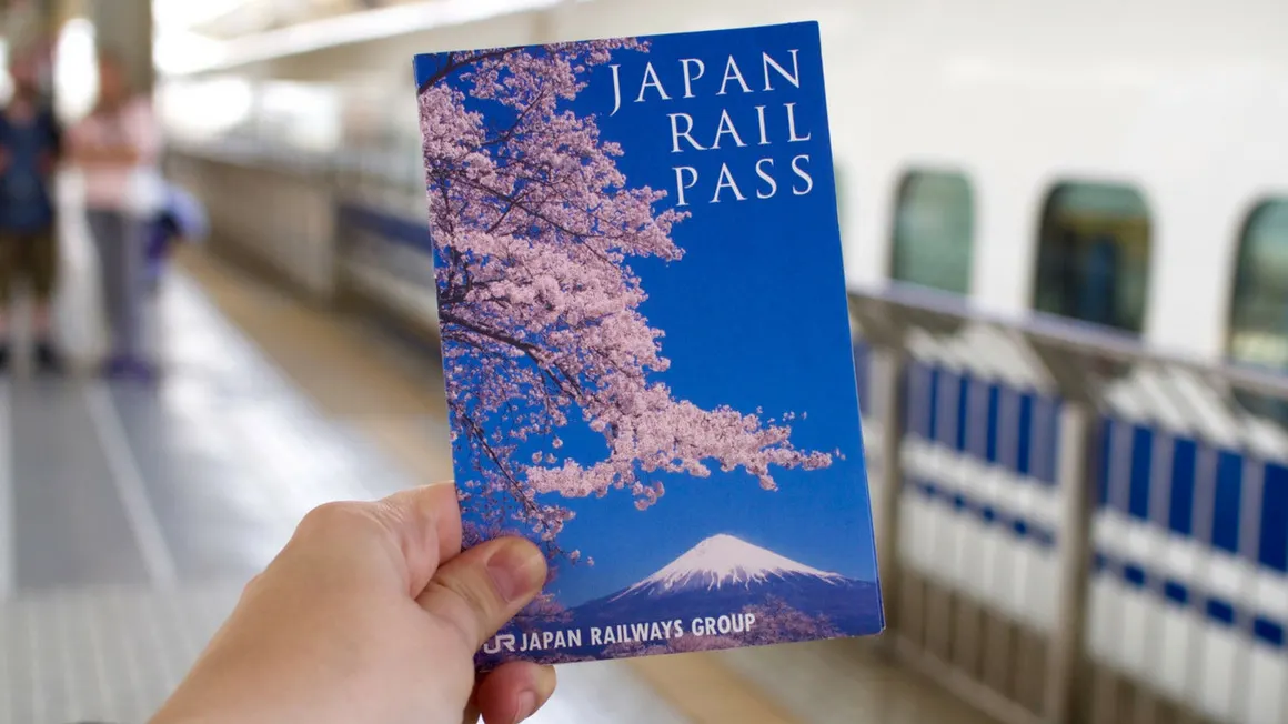Japan Rail Pass held at a train station, perfect for exploring scenic Japan tour spots.
