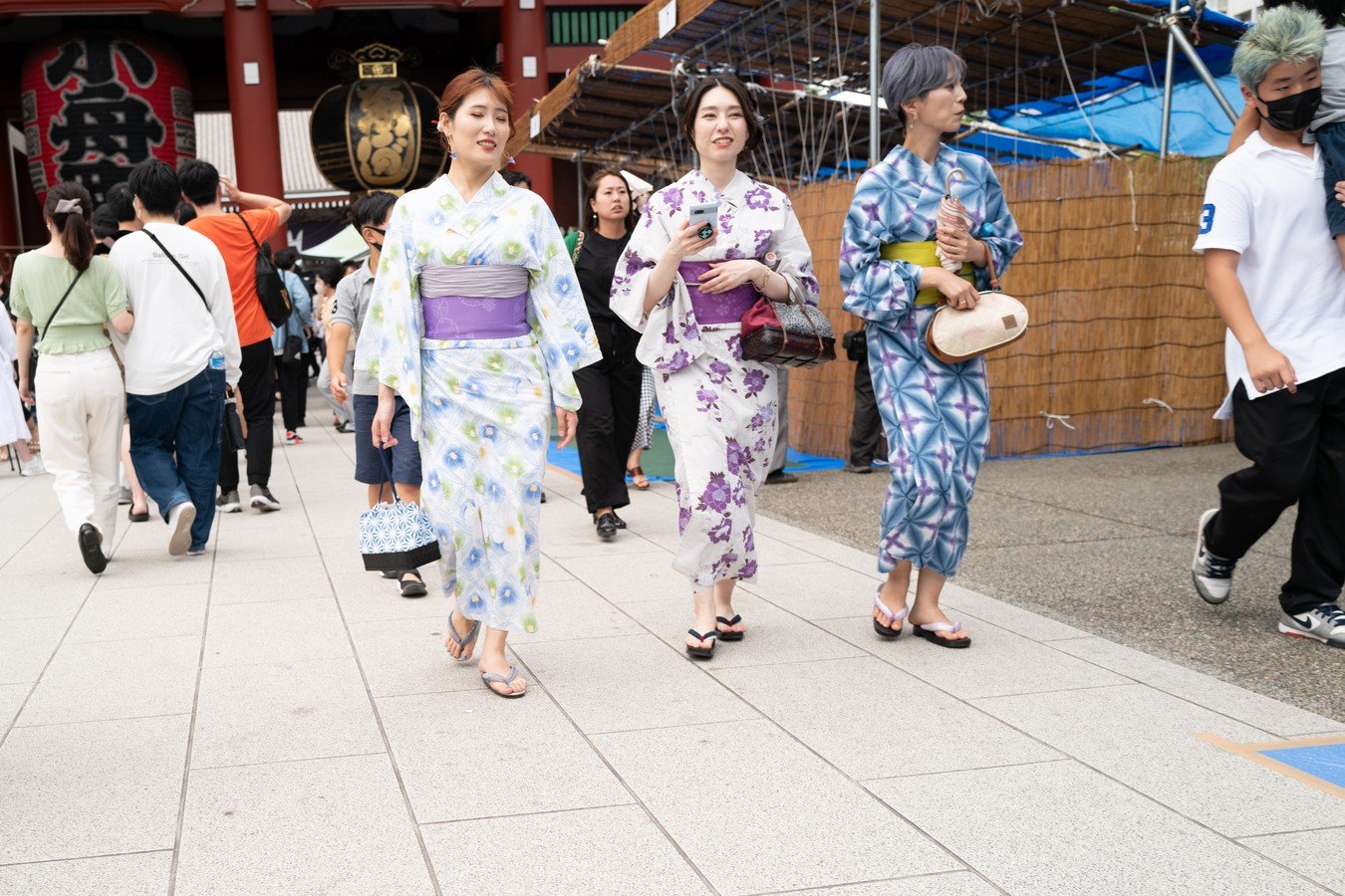 Women in traditional kimonos strolling in a vibrant Japanese street during a cultural tour.
