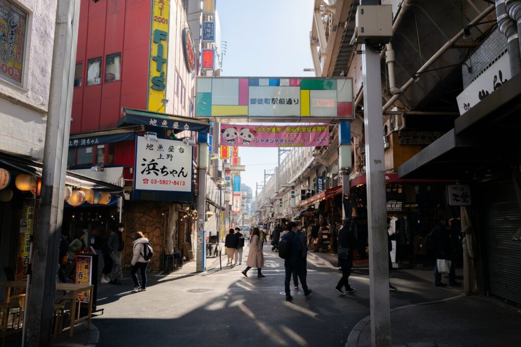 Bustling Tokyo street with shops and pedestrians, showcasing authentic urban life. Ideal scene for Japan tours.