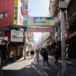 Bustling Tokyo street with shops and pedestrians, showcasing authentic urban life. Ideal scene for Japan tours.