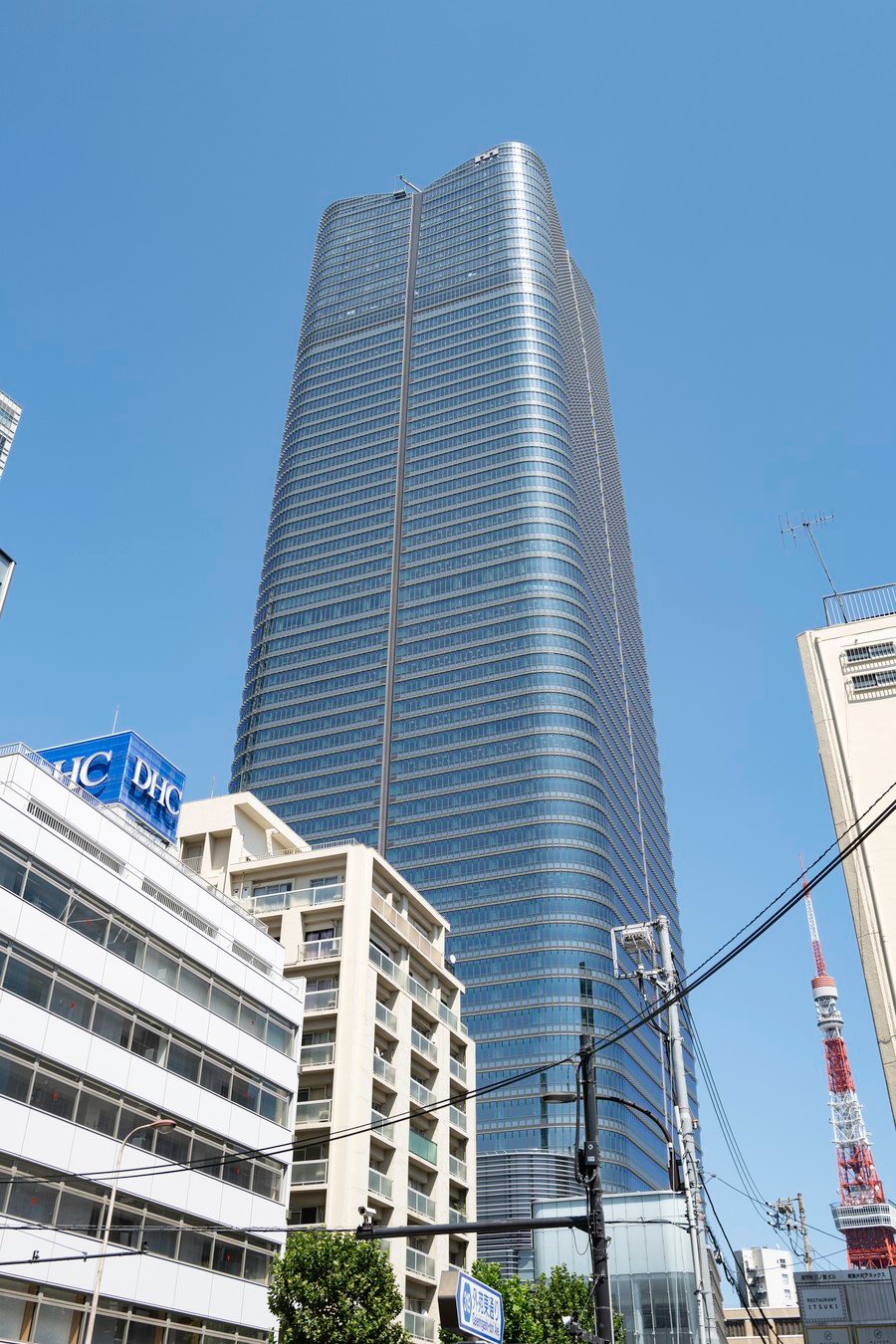 Modern skyscraper and Tokyo Tower on a clear day, ideal for Japan tour itineraries exploring urban landscapes.