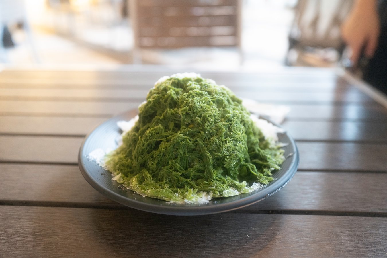 Matcha shaved ice dessert, a Japanese summer treat, enjoyed during Japan tours. Refreshing and unique culinary experience.