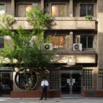 Urban street scene in Japan with a vintage building and a tree, suitable for cultural and historical tours.