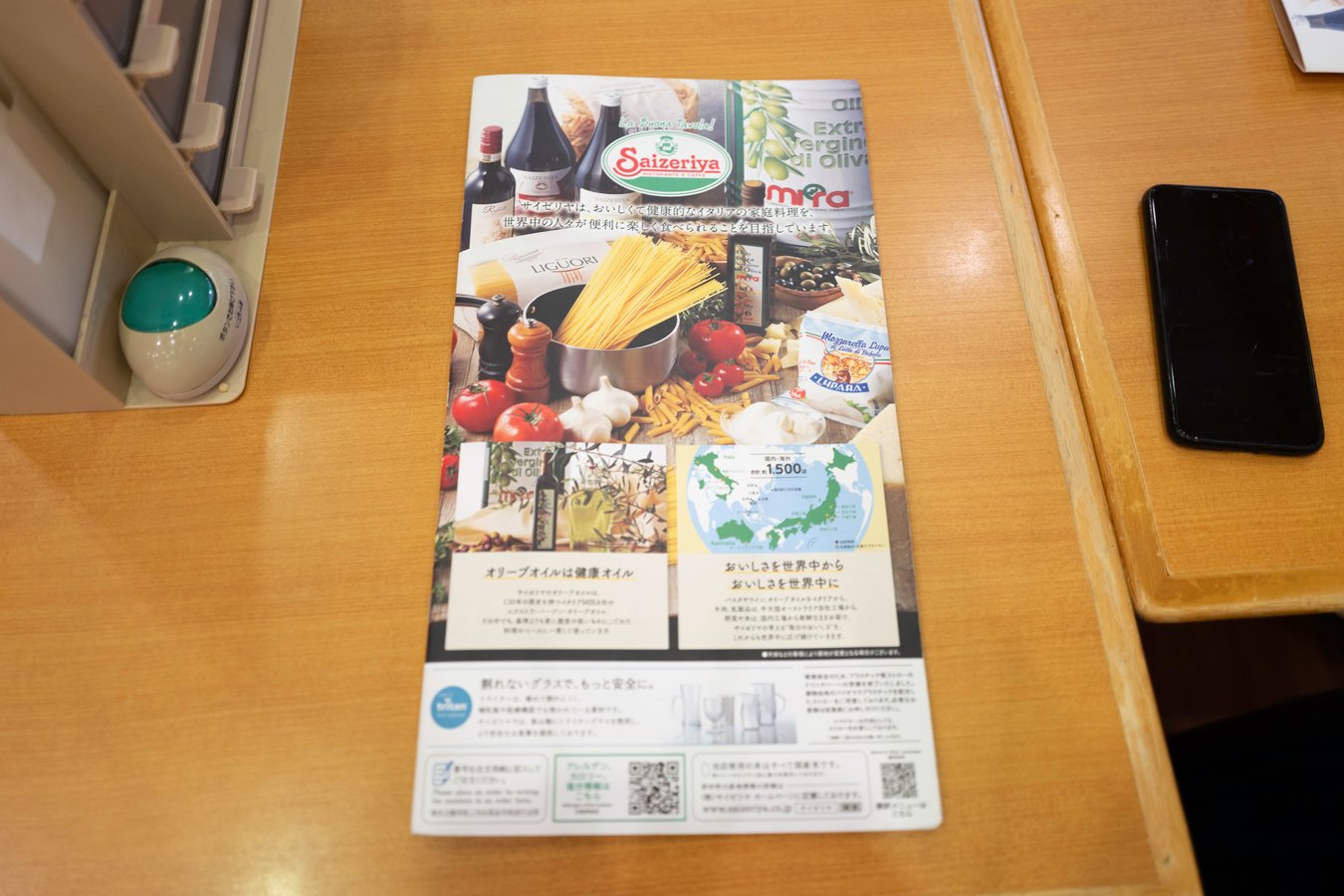 Colorful Saizeriya menu on wooden table, featuring Italian cuisine. Ideal dining spot for Japan tours.