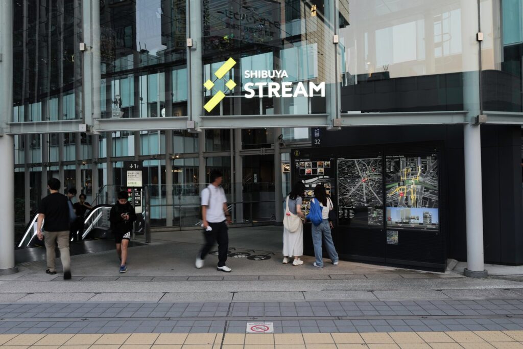 Visitors at Shibuya Stream entrance, Tokyo—a vibrant spot on Japan tours, perfect for dining and shopping.