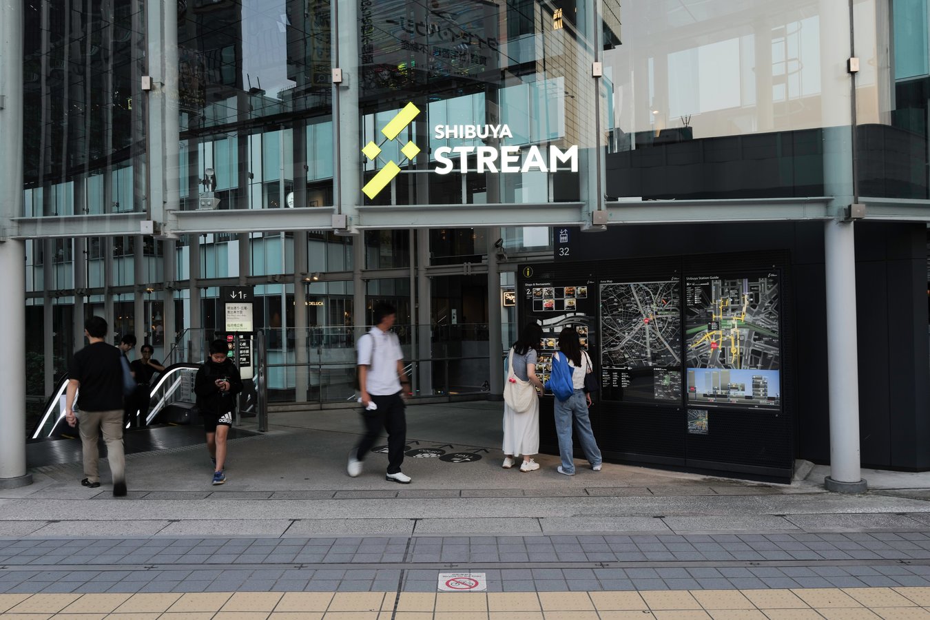 Visitors at Shibuya Stream entrance, Tokyo—a vibrant spot on Japan tours, perfect for dining and shopping.