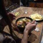 Person enjoying traditional Japanese curry dish at a local restaurant, highlighting authentic culinary experiences in Japan.