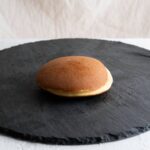 Traditional Japanese dorayaki pancake on a slate plate, featured on our cultural Japan tours website.