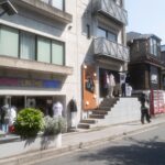 Tokyo street shops displaying trendy clothing on a bright day, perfect for fashion-focused Japan tours.