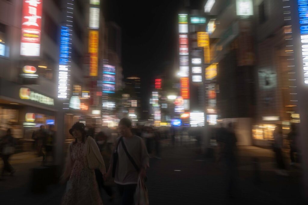 Nightlife in Tokyo's vibrant city streets, illuminated by neon signs, showcasing dynamic urban experiences on Japan tours.