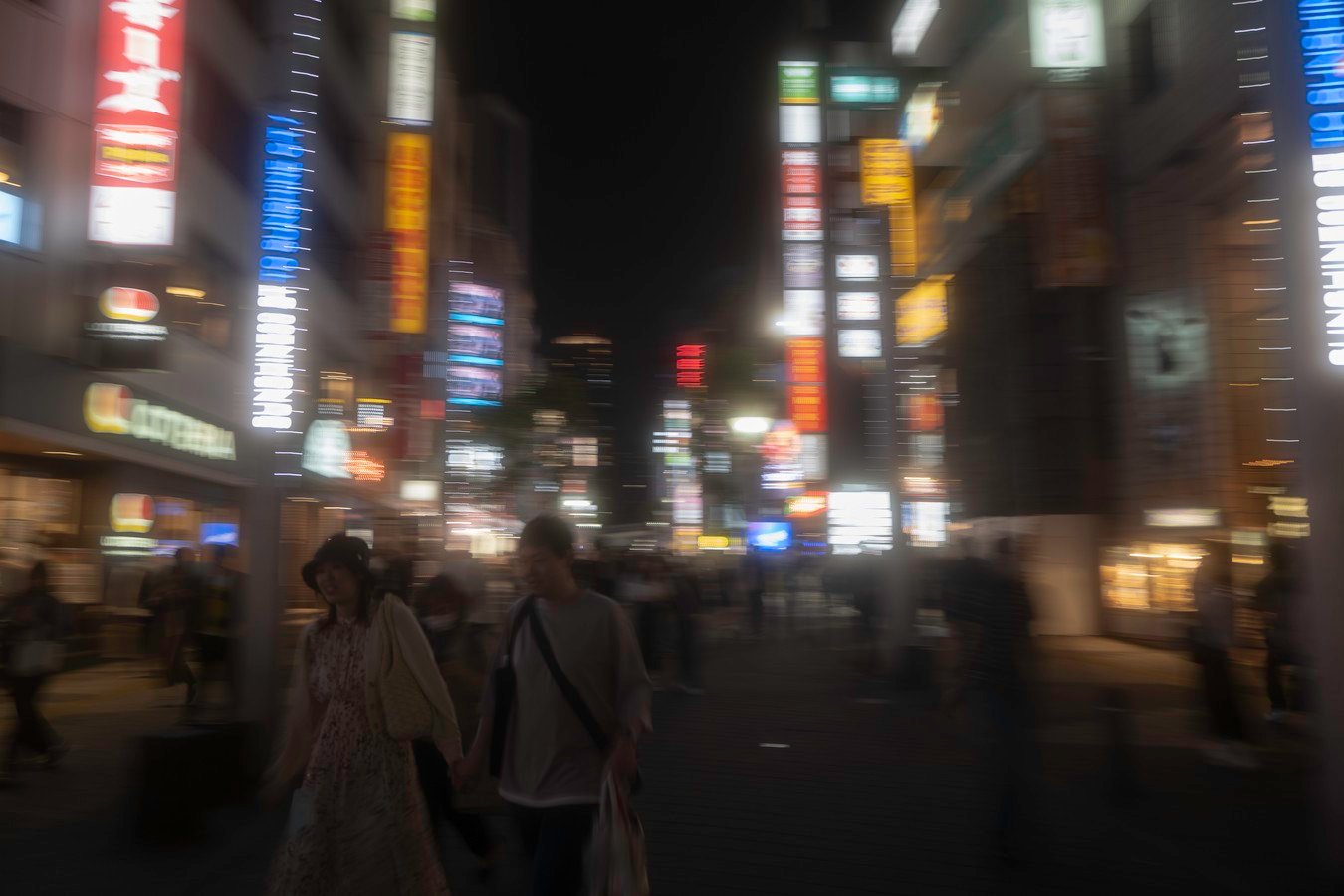 Nightlife in Tokyo's vibrant city streets, illuminated by neon signs, showcasing dynamic urban experiences on Japan tours.