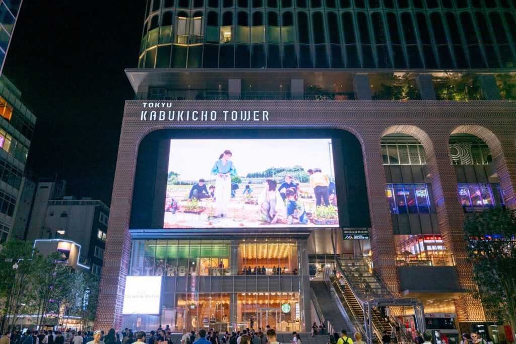 Night view of Tokyo's Kabukicho Tower bustling with tourists, highlighting vibrant nightlife on Japan tours.