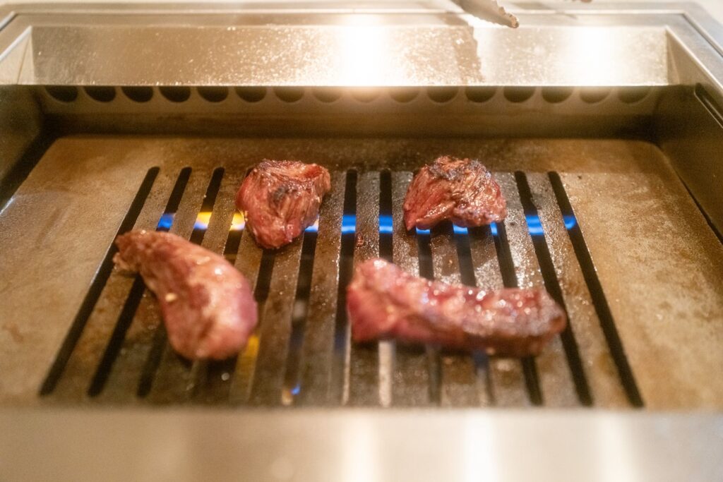 Grilling succulent Wagyu beef in a traditional Japanese barbecue style for an authentic Japan tour experience.
