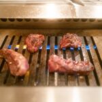 Grilling succulent Wagyu beef in a traditional Japanese barbecue style for an authentic Japan tour experience.