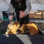 Street vendor cooking yakisoba at a Japanese market, showcasing local cuisine on a Japan tour adventure.