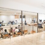 Modern Japanese café ambiance in Tokyo, featuring visitors enjoying coffee and conversation during a Japan tour.
