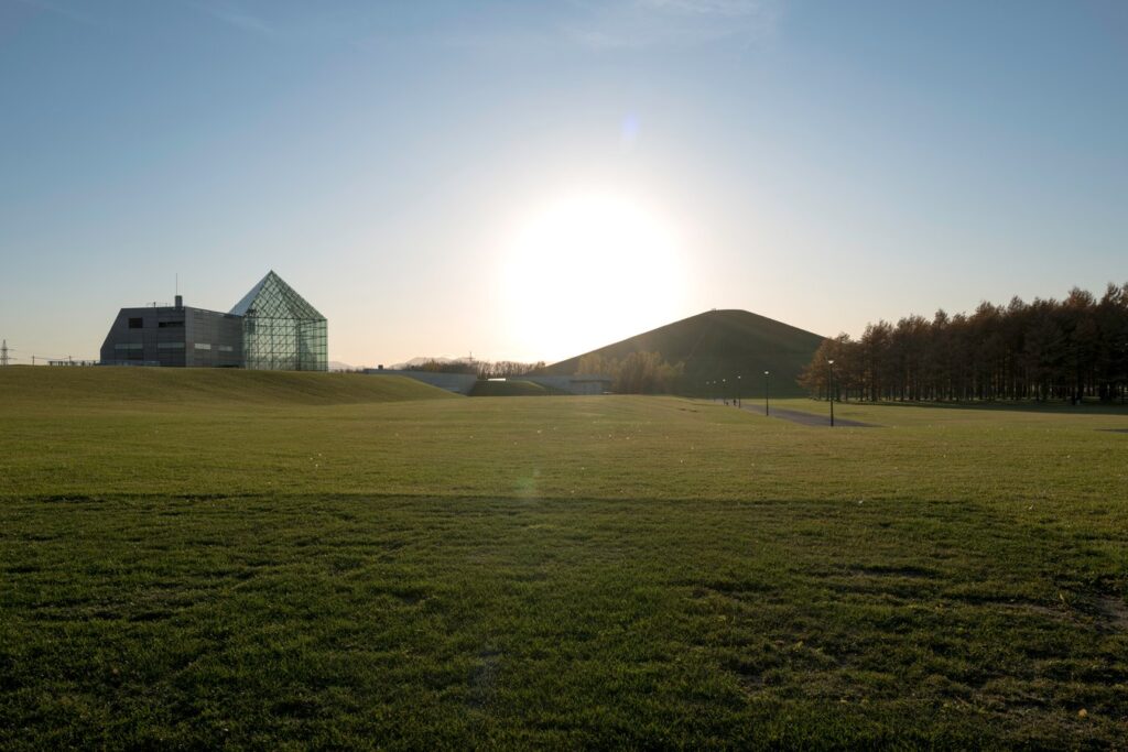 Sunset over Moerenuma Park's glass pyramid in Sapporo, Japan. Discover serene landscapes on your Japan tour.