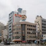 Giant chef statue on Niimi building in Tokyo's Kappabashi Street, a must-see on Japan culinary tours.