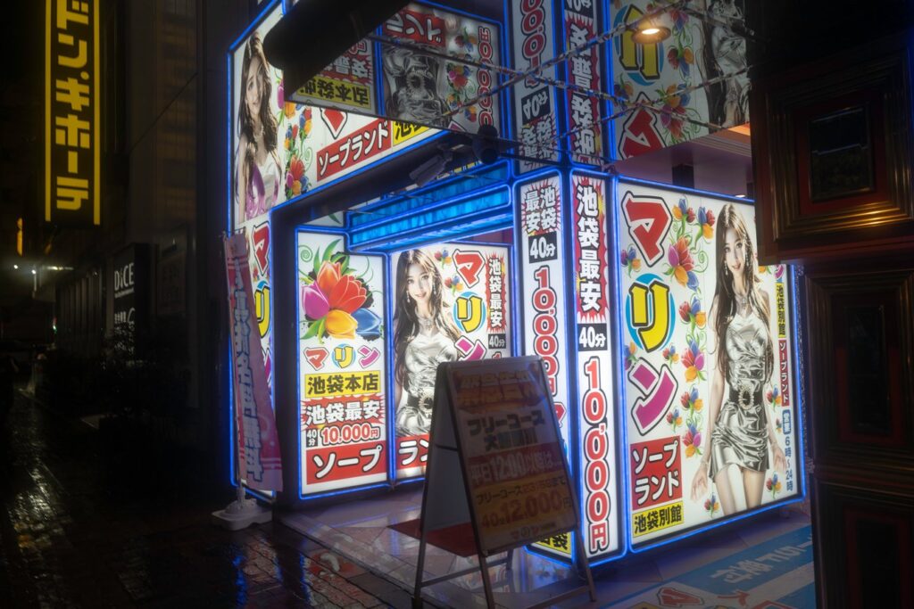 Brightly lit street in Tokyo with colorful signs, showcasing vibrant nightlife on a Japan tour.