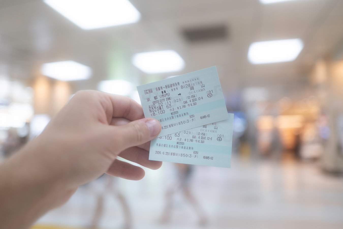 Hand holding Japan train tickets, ideal for exploring scenic rail routes on Japan tours.